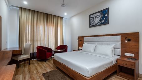 A Club Balcony Room featuring a bed, a teapoy and chairs at DLS The Classio